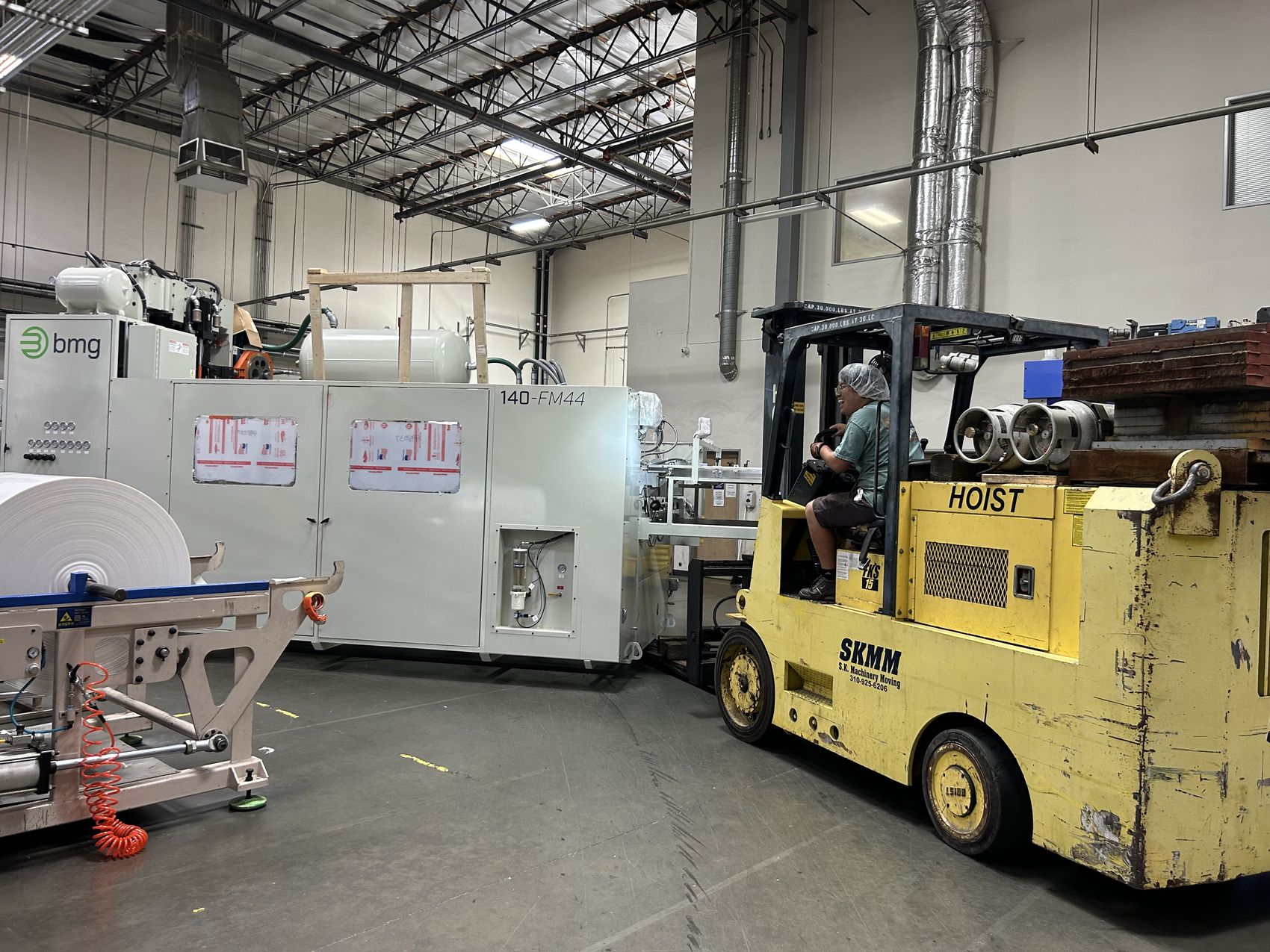 S.K. Machinery Moving forklift relocating a large industrial production machine